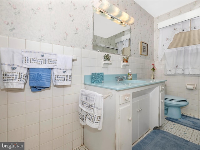 bathroom featuring a shower, tile walls, vanity, toilet, and tile patterned floors