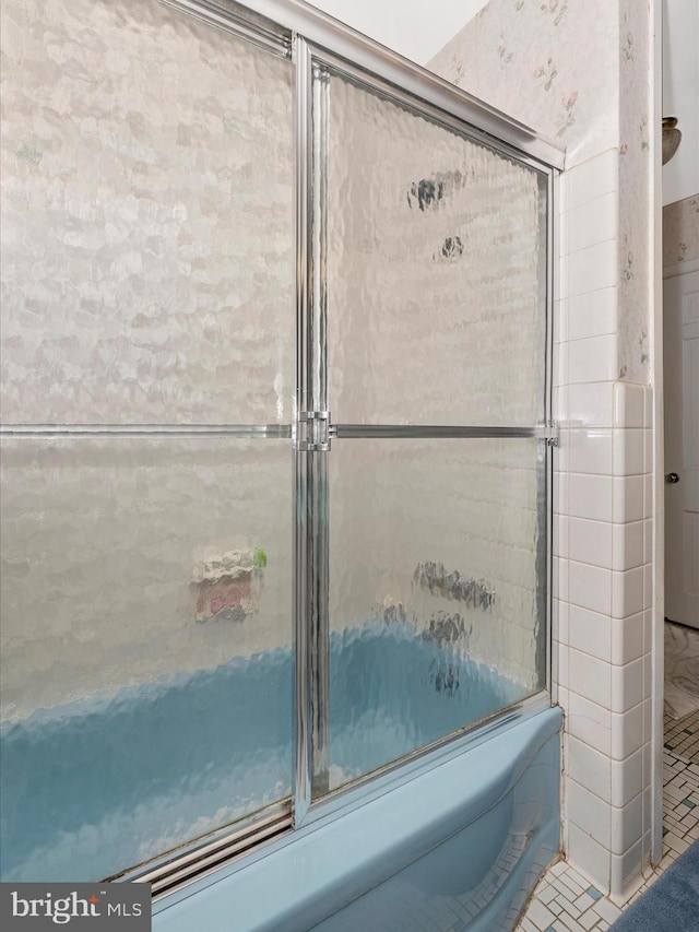 bathroom featuring bath / shower combo with glass door