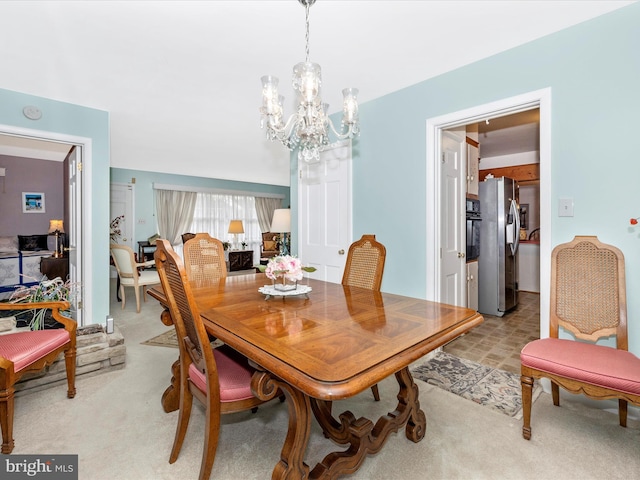 dining room with light colored carpet and a chandelier