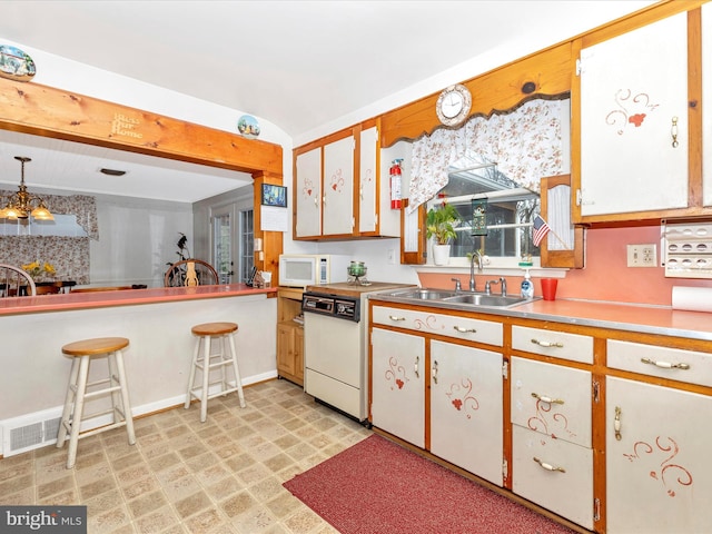 kitchen featuring pendant lighting, white cabinetry, sink, white appliances, and beam ceiling