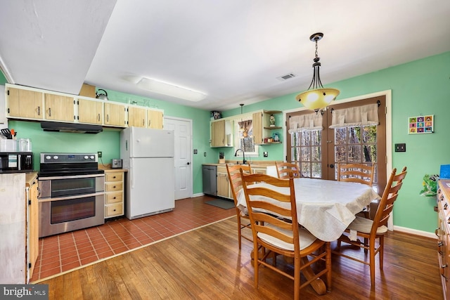 tiled dining room with sink and french doors