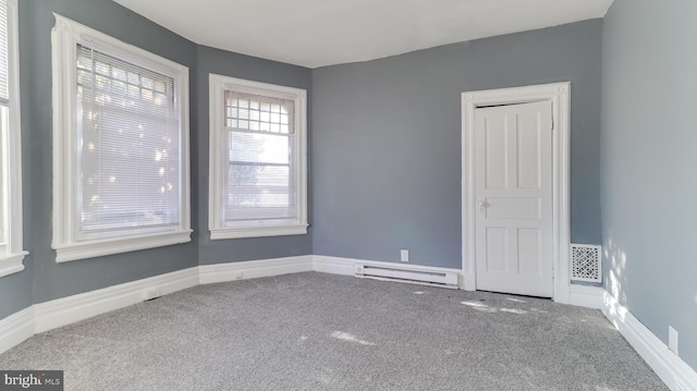 carpeted spare room featuring visible vents, baseboards, and a baseboard radiator