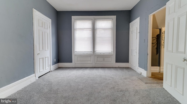 unfurnished bedroom featuring baseboards and carpet