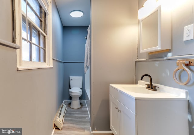 bathroom featuring vanity, a shower with shower curtain, wood finished floors, baseboards, and toilet