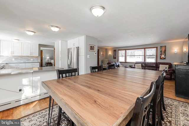 dining space featuring light hardwood / wood-style floors and baseboard heating