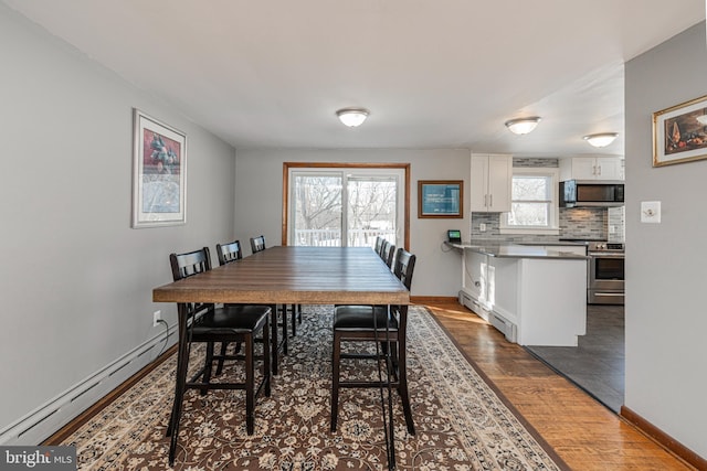 dining area featuring baseboard heating and dark hardwood / wood-style flooring