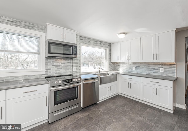 kitchen featuring sink, decorative backsplash, stainless steel appliances, and white cabinets