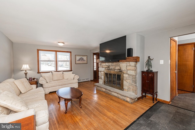 living room featuring a fireplace, a baseboard radiator, and hardwood / wood-style floors