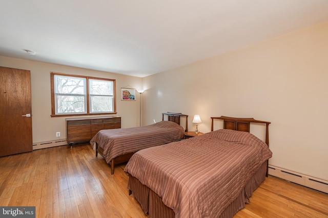 bedroom featuring a baseboard radiator and light hardwood / wood-style flooring