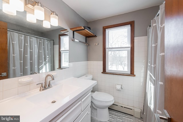 bathroom featuring vanity, toilet, tile walls, and a baseboard heating unit