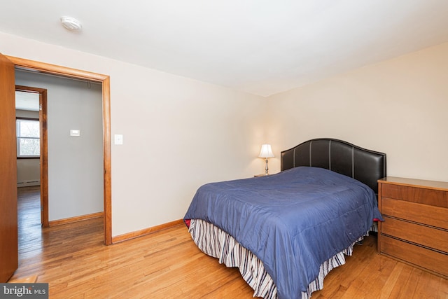 bedroom featuring hardwood / wood-style floors and baseboard heating