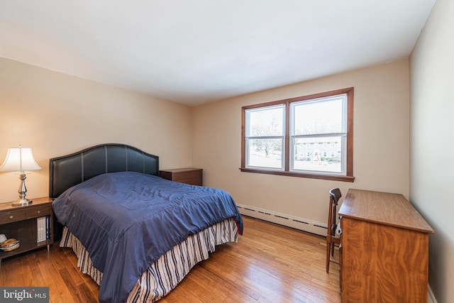 bedroom with light hardwood / wood-style flooring and a baseboard radiator