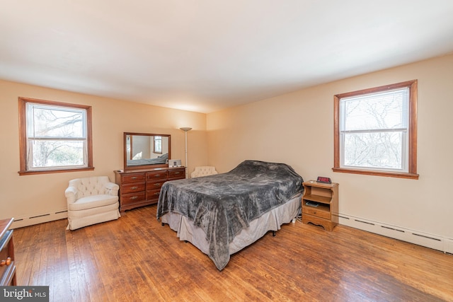 bedroom featuring hardwood / wood-style floors and baseboard heating