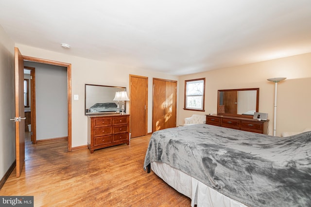 bedroom featuring multiple closets and hardwood / wood-style floors