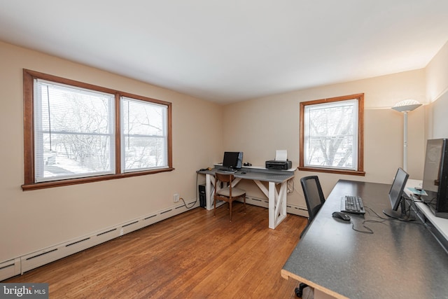 home office featuring a baseboard heating unit and light hardwood / wood-style flooring