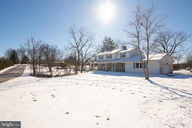 snow covered property with a garage