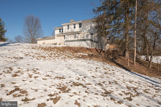 view of snow covered back of property