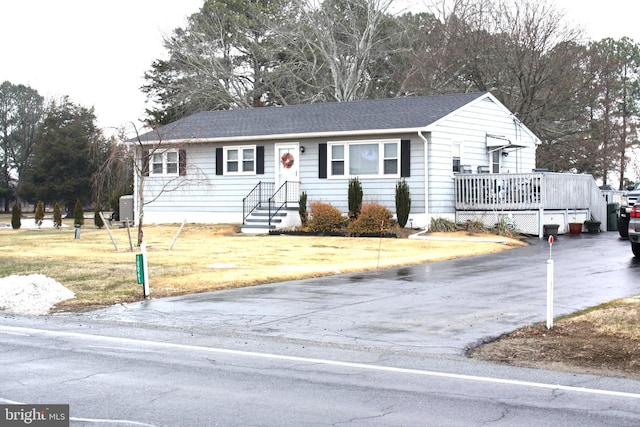 single story home with a deck and a front lawn