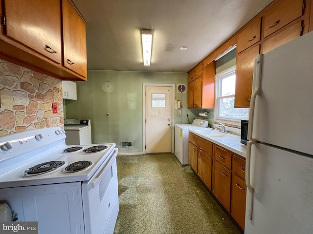 kitchen with washer and clothes dryer, sink, and white appliances