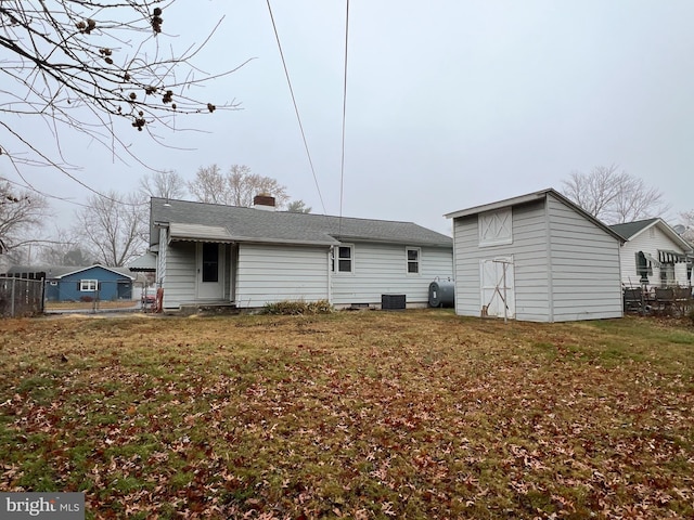 back of house with a yard and central air condition unit