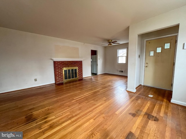 unfurnished living room featuring ceiling fan, a fireplace, and hardwood / wood-style flooring