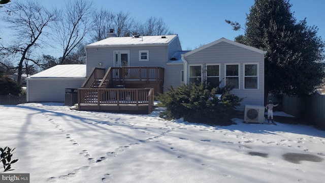 snow covered property with ac unit and a deck