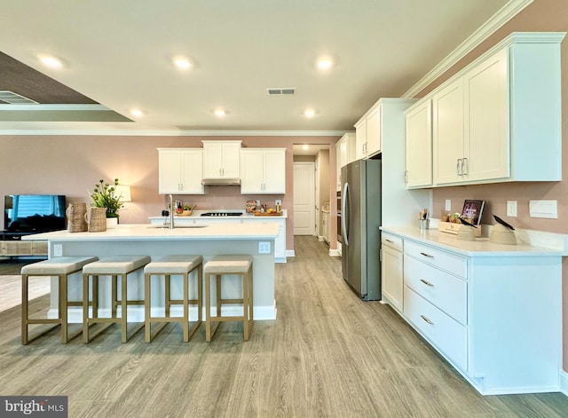 kitchen featuring light hardwood / wood-style floors, stainless steel fridge, white cabinets, and crown molding