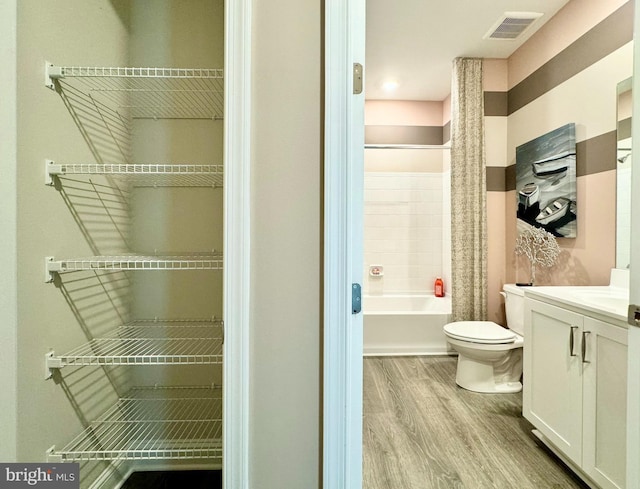 full bathroom featuring hardwood / wood-style floors, toilet, vanity, and shower / bath combination with curtain