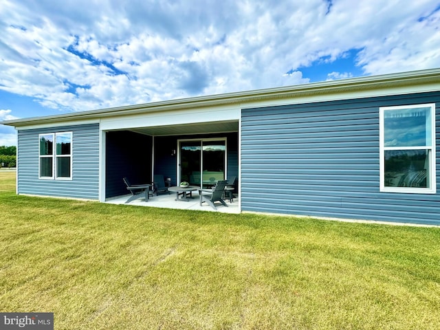 rear view of property with a lawn and a patio area