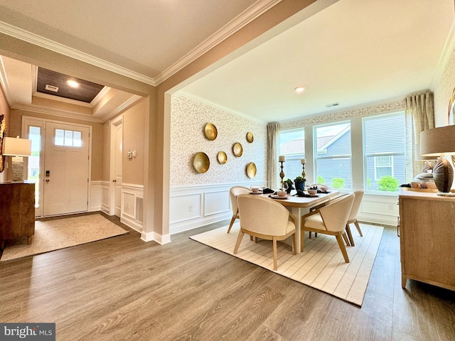 dining space with crown molding and hardwood / wood-style flooring