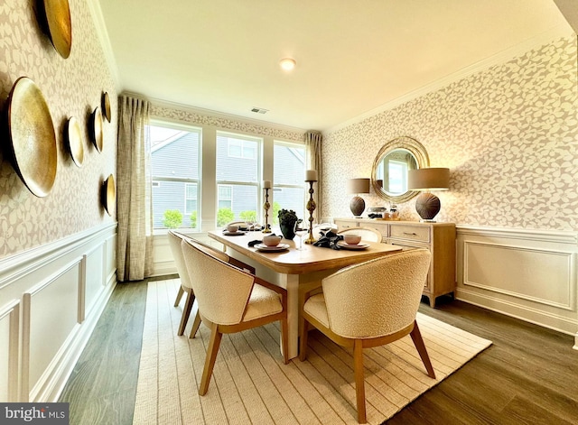 dining area featuring wood-type flooring and crown molding