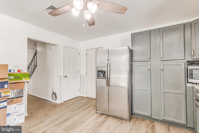 kitchen with light hardwood / wood-style floors, appliances with stainless steel finishes, gray cabinets, and ceiling fan