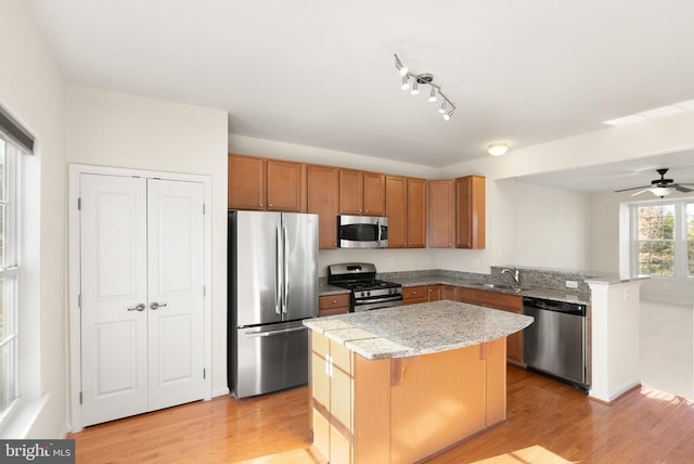 kitchen with a kitchen bar, a kitchen island, stainless steel appliances, and a sink