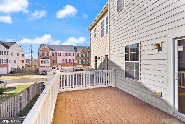 wooden terrace with a residential view and fence