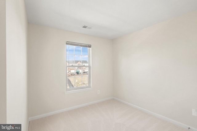 spare room with light carpet, baseboards, and visible vents