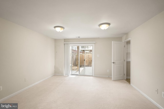 unfurnished room with baseboards and light colored carpet