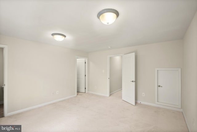 unfurnished bedroom featuring baseboards and light colored carpet