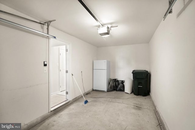 garage featuring freestanding refrigerator and a garage door opener