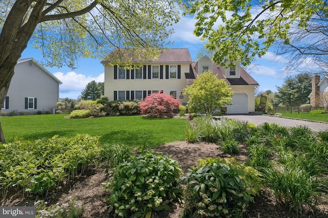 colonial inspired home with a front lawn and a garage