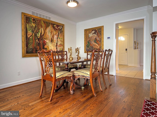 dining space featuring crown molding and light wood-type flooring