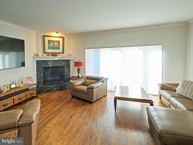 living room featuring a high end fireplace, crown molding, and hardwood / wood-style floors