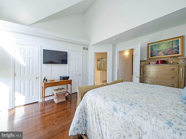 bedroom with dark wood-type flooring, ensuite bathroom, and high vaulted ceiling