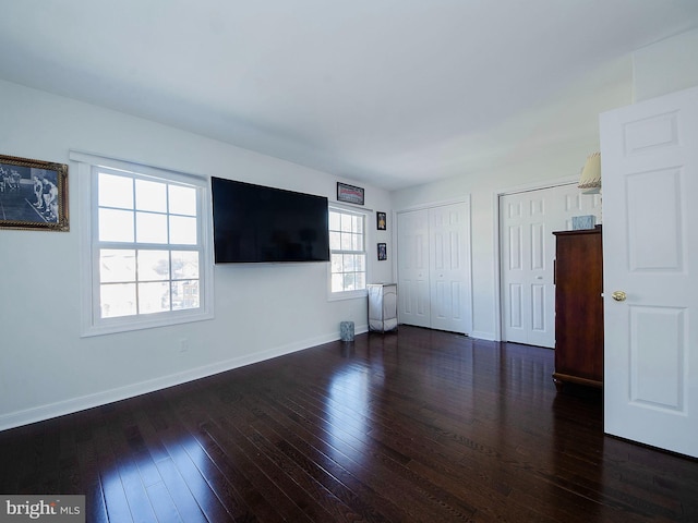 unfurnished living room with dark wood-type flooring