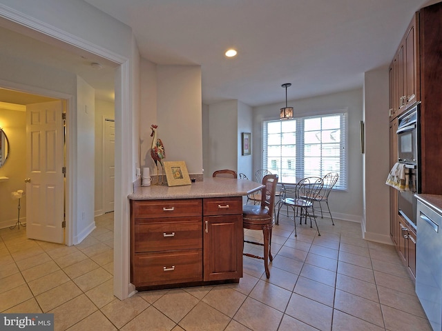 kitchen with oven, light tile patterned floors, stainless steel dishwasher, and decorative light fixtures