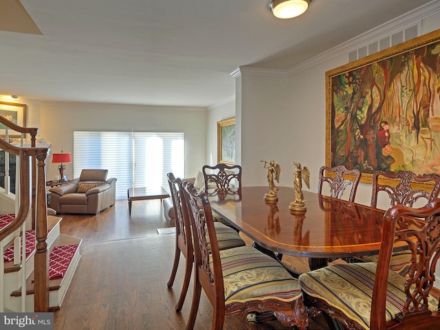 dining space featuring hardwood / wood-style flooring and ornamental molding