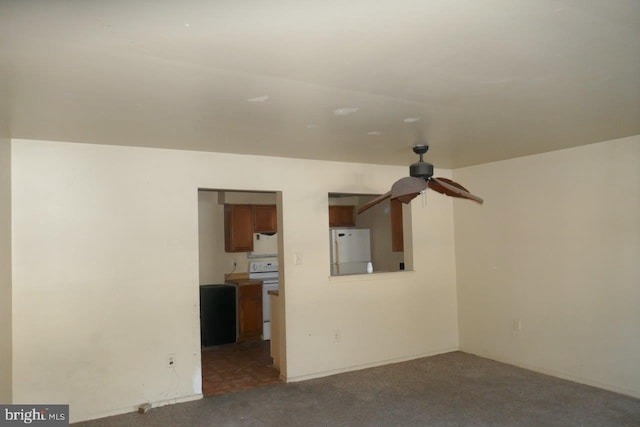 unfurnished living room with ceiling fan and dark carpet