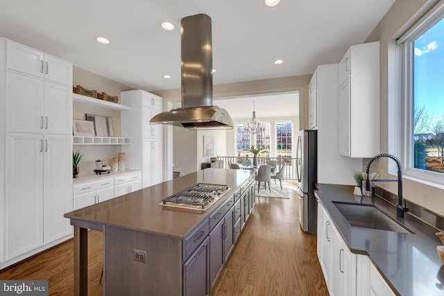 kitchen featuring open shelves, stainless steel appliances, dark countertops, white cabinets, and island range hood