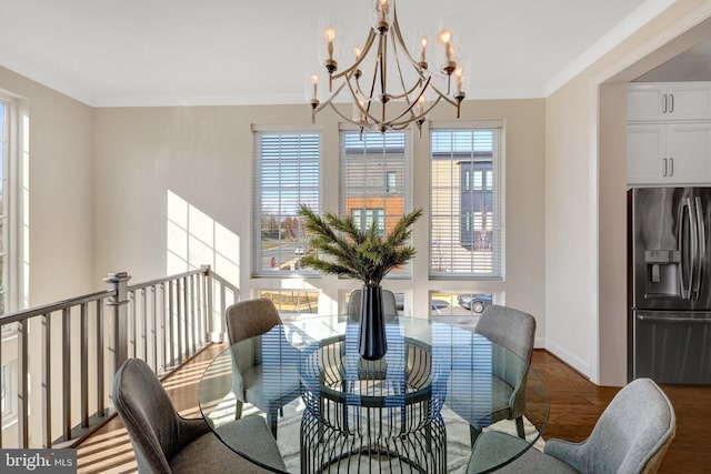 dining room with an inviting chandelier, crown molding, baseboards, and wood finished floors