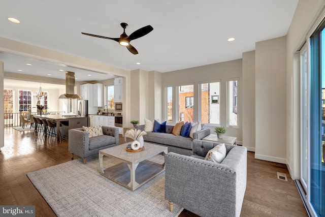 living area with light wood finished floors, visible vents, a wealth of natural light, and recessed lighting