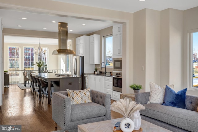 living area featuring a notable chandelier, wood finished floors, and recessed lighting